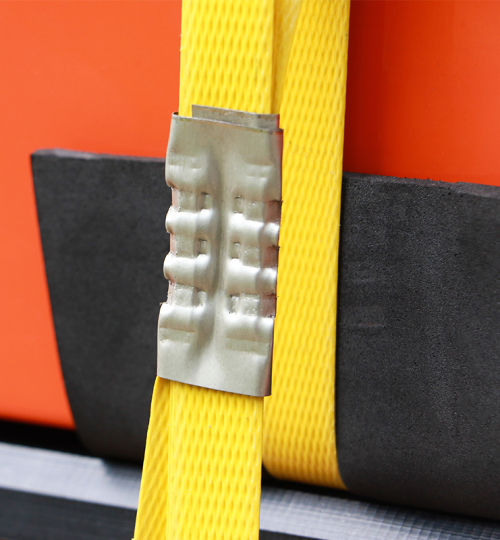 close-up-photo-of-yellow-steel-strapping-securing-large-orange-product